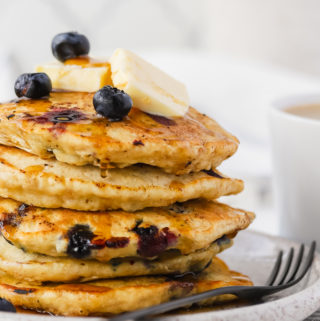 large close up stack of blueberry oatmeal pancakes on a plate