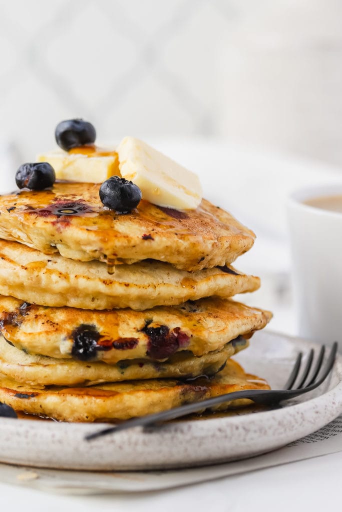 large close up stack of blueberry oatmeal pancakes on a plate