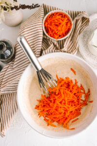 a bowl with pancake batter and carrots mixed in