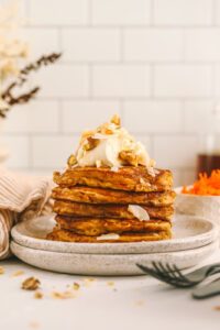 a closeup of carrot cake oatmeal pancakes topped with cream cheese