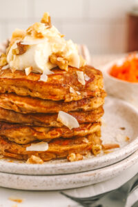 a closeup of carrot cake oatmeal pancakes topped with cream cheese