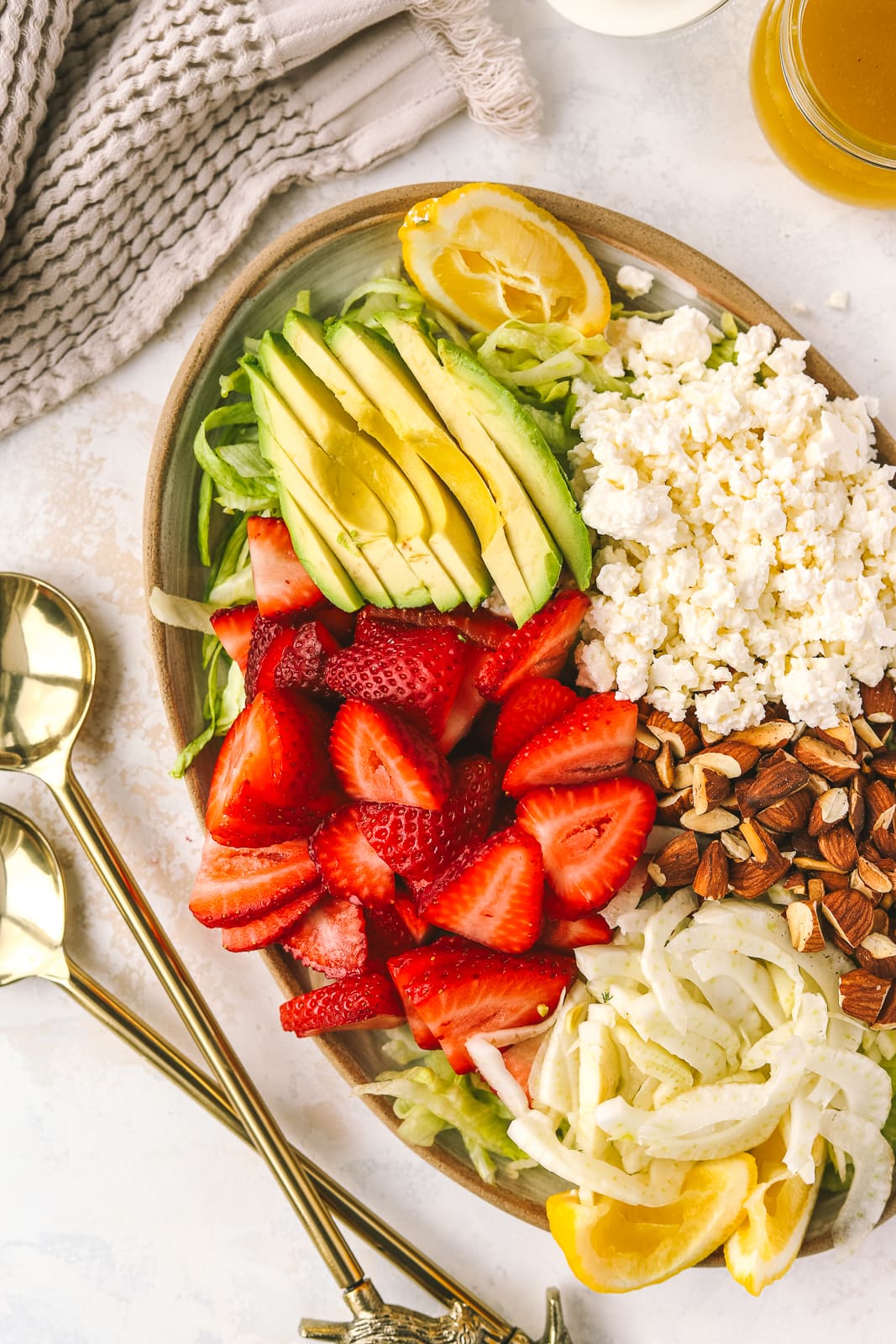 strawberries, avocado, feta, almonds and lettuce on a plate