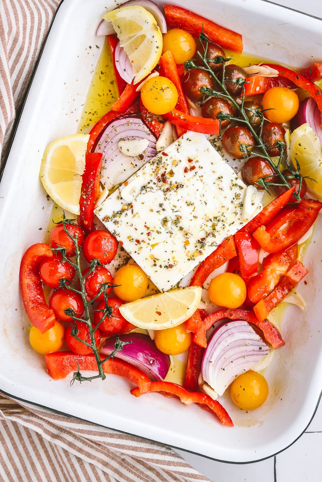 feta in a pan with summer vegetables before being baked