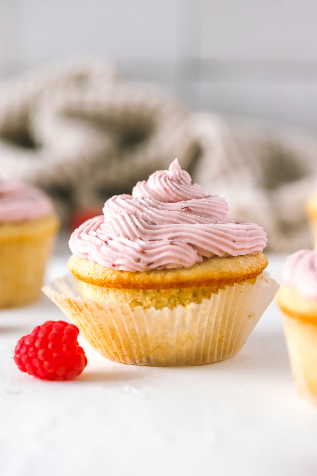 vanilla cupcake topped with raspberry cream cheese frosting