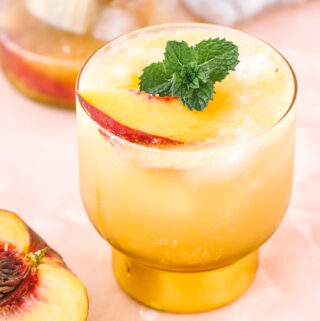 angled shot of peach whiskey cocktail in a cocktail glass