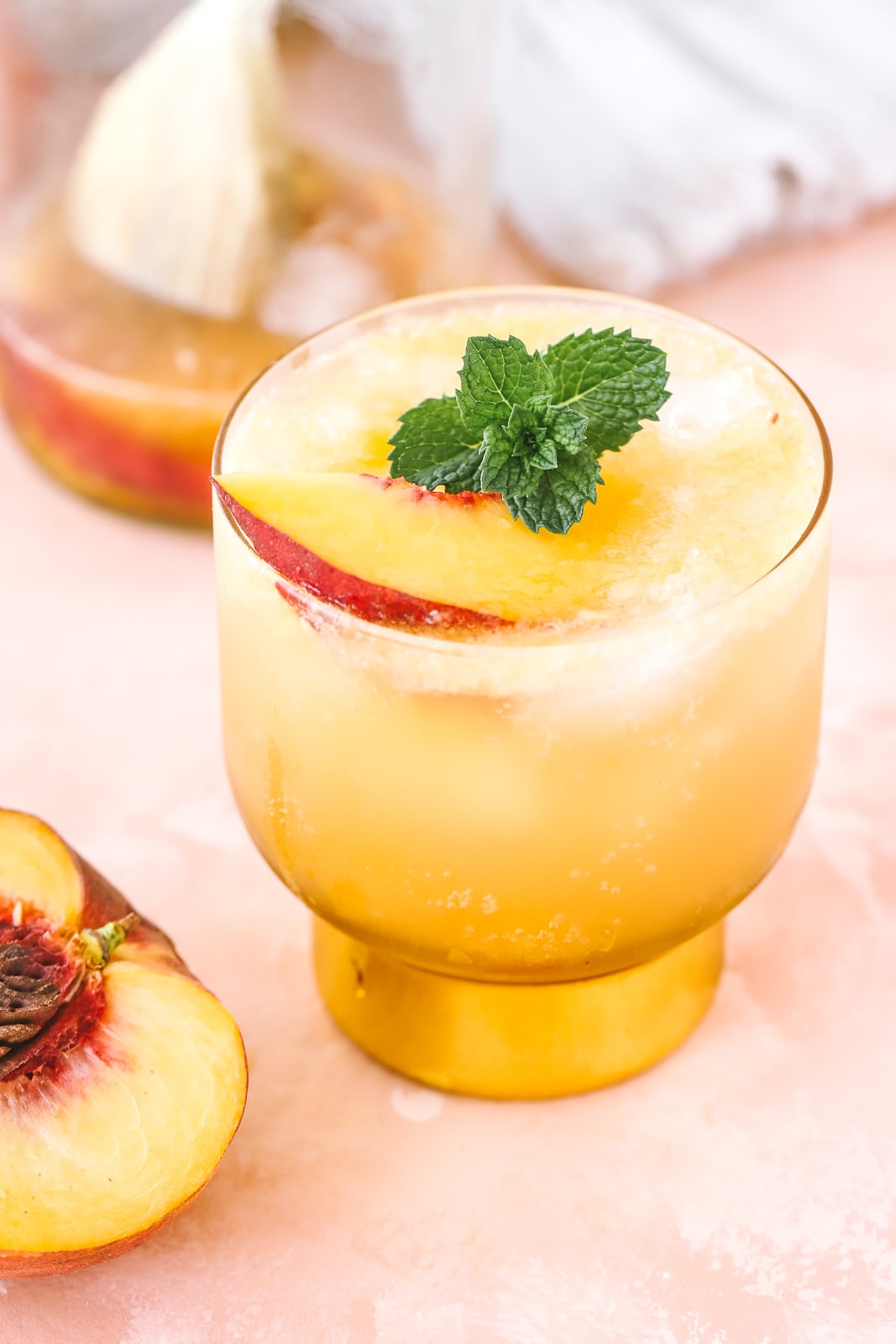 angled shot of peach whiskey cocktail in a cocktail glass