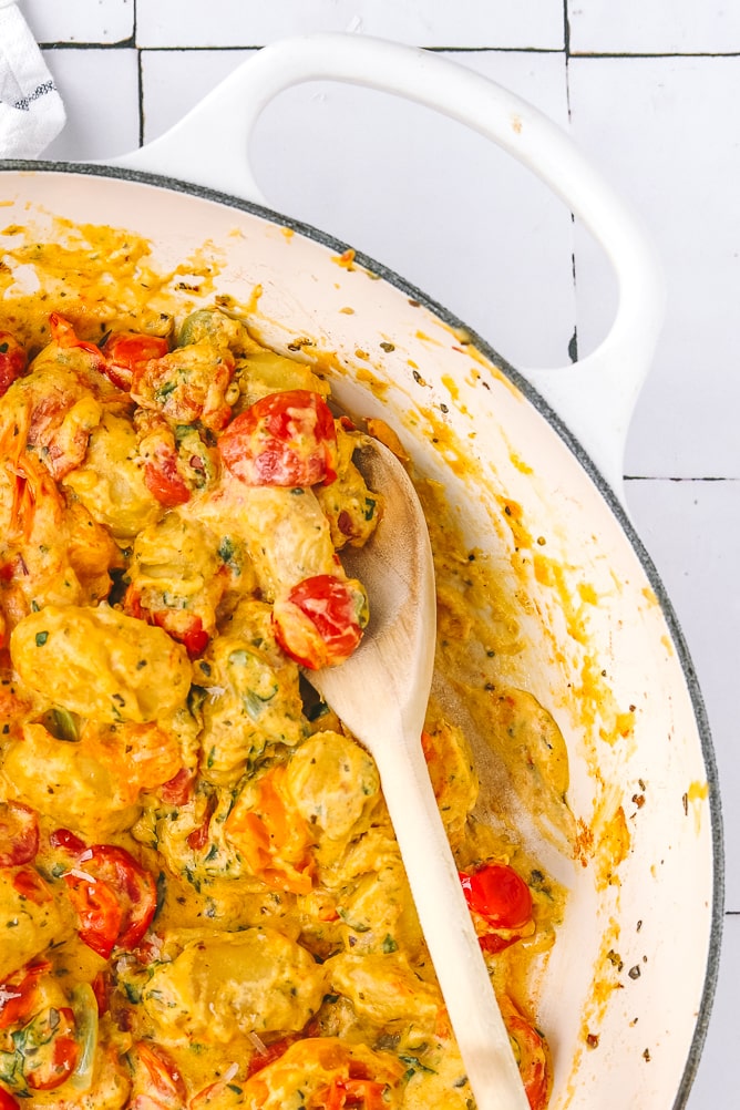 serving spoon in a pan of baked gnocchi