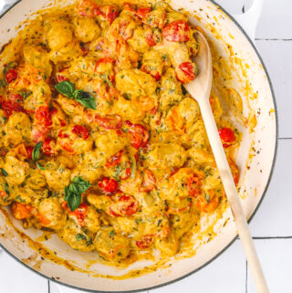 serving spoon in a pan of baked gnocchi