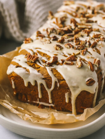 maple icing drizzle with pecans on pumpkin loaf