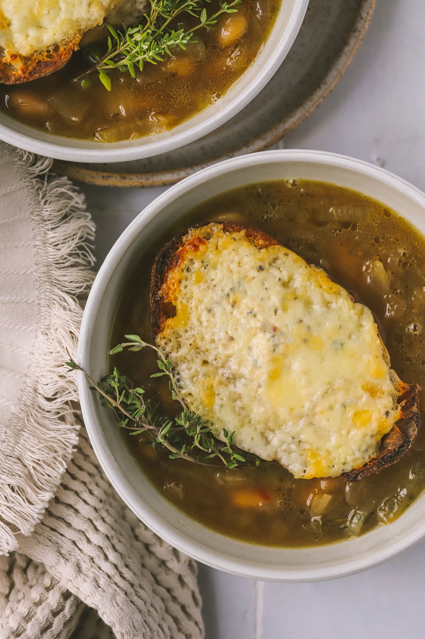 top view of cheesy toast on top of bean soup