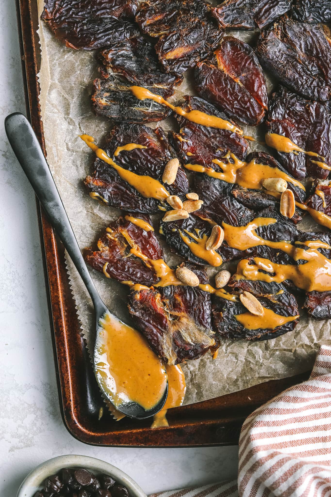 spoon with peanut butter on a tray with dates