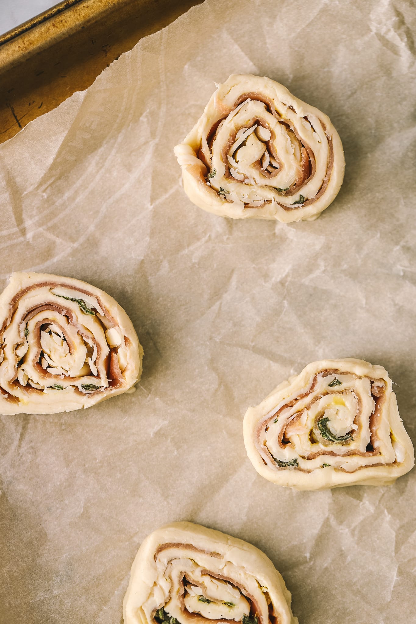 puff pastry pinwheels on a baking sheet before being baked