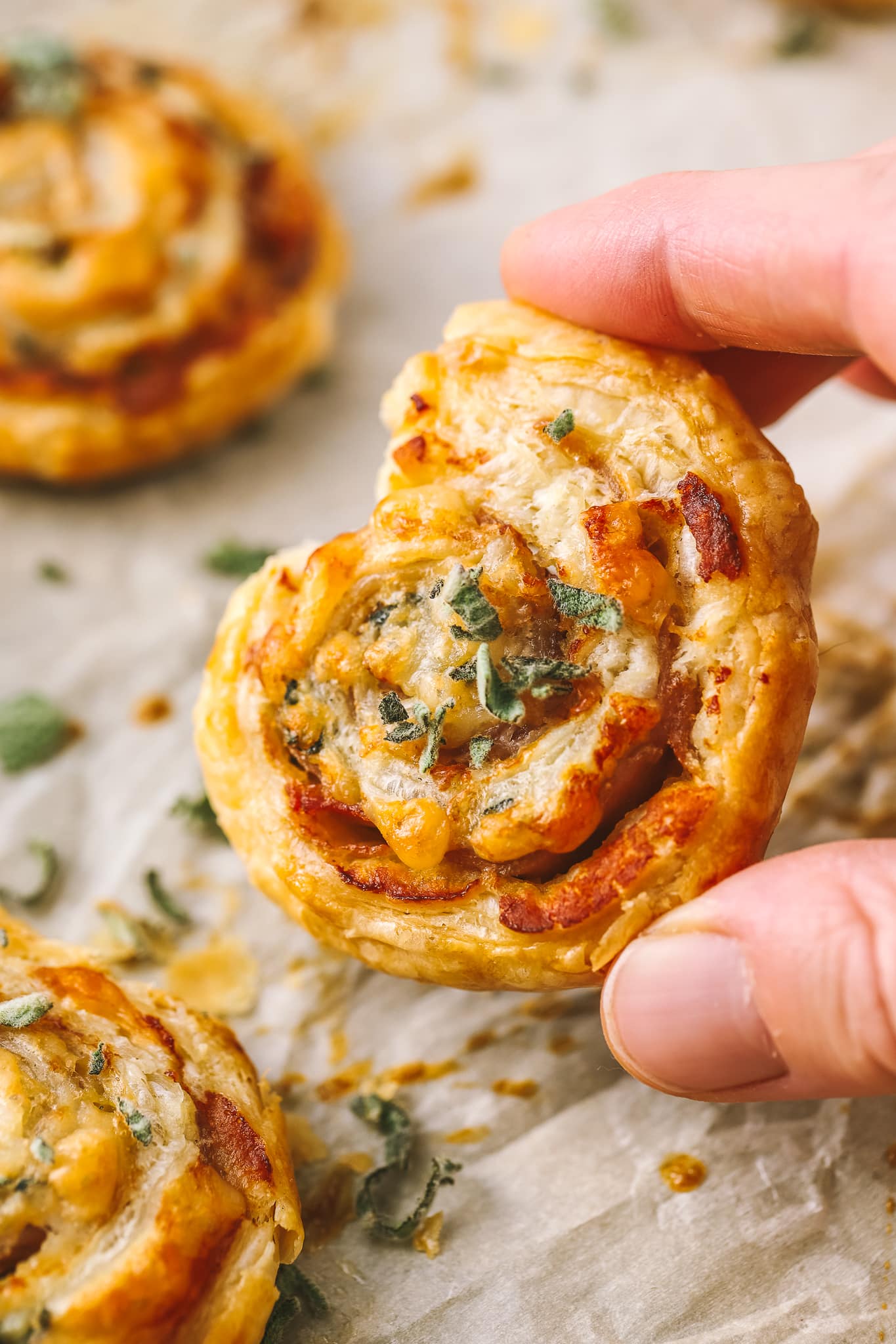 hand holding sage prosciutto puff pastry bites