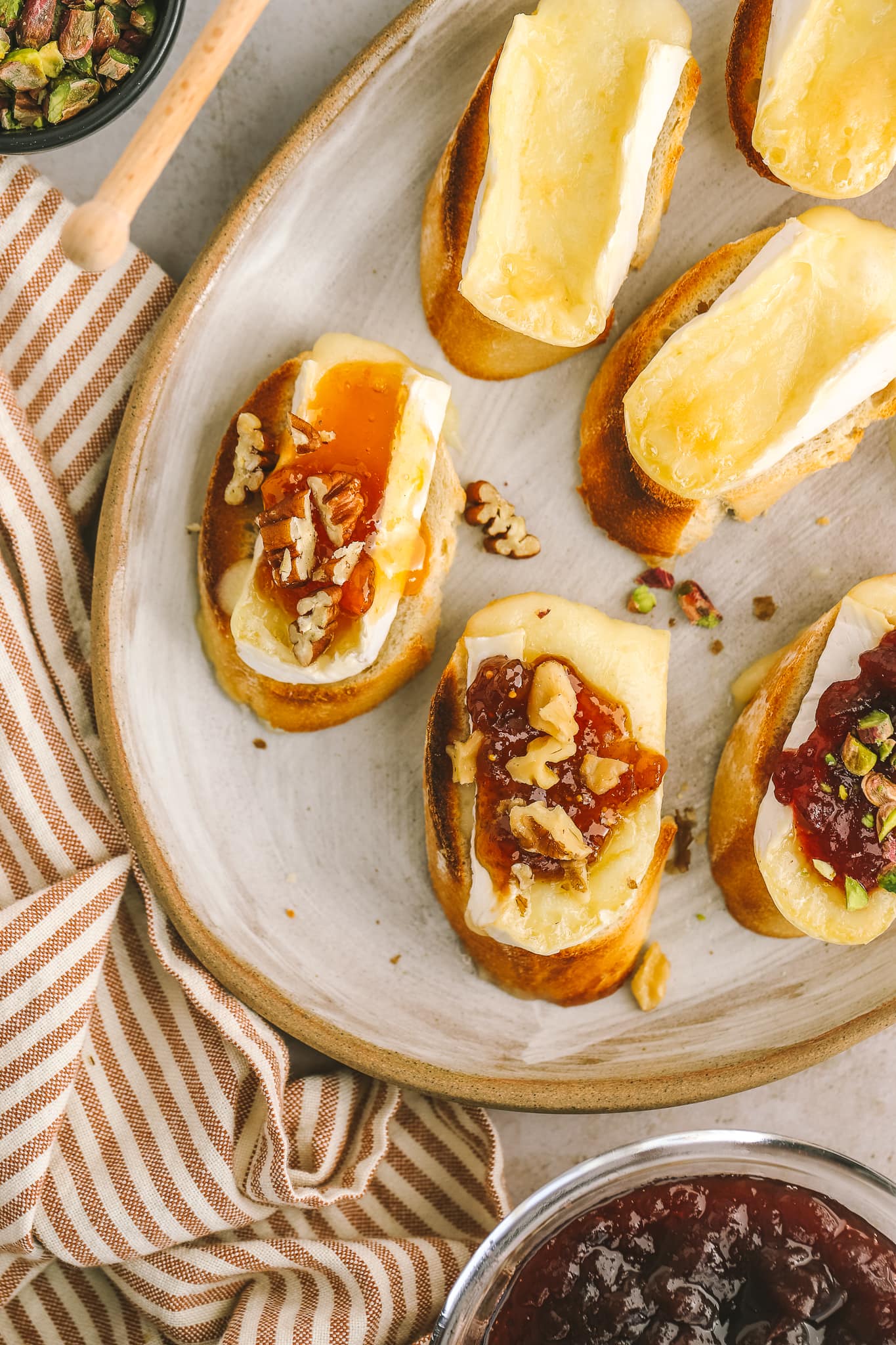 closeup of baguette with brie cheese, apricot jam and pecans