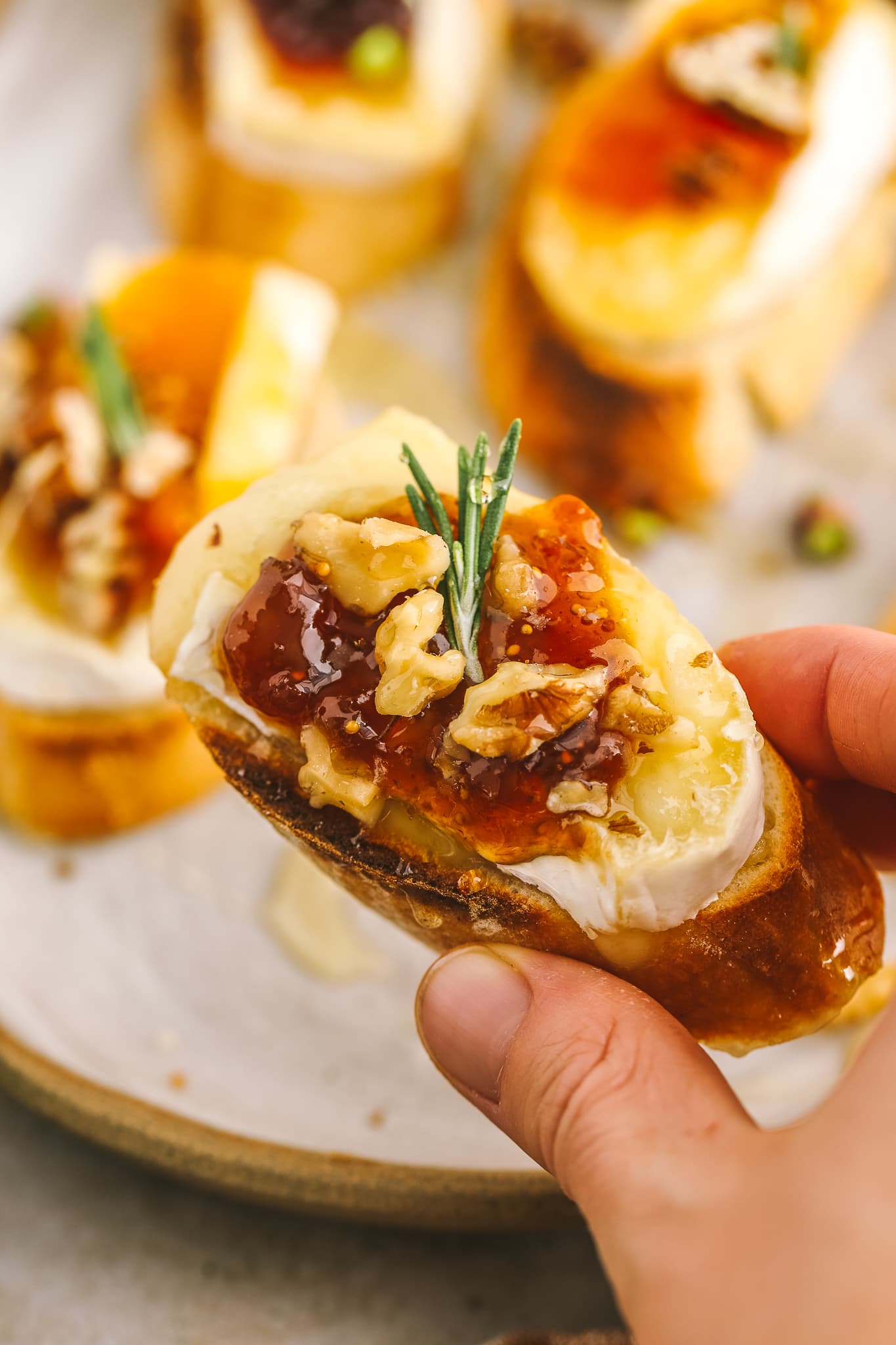 hand holding brie crostini