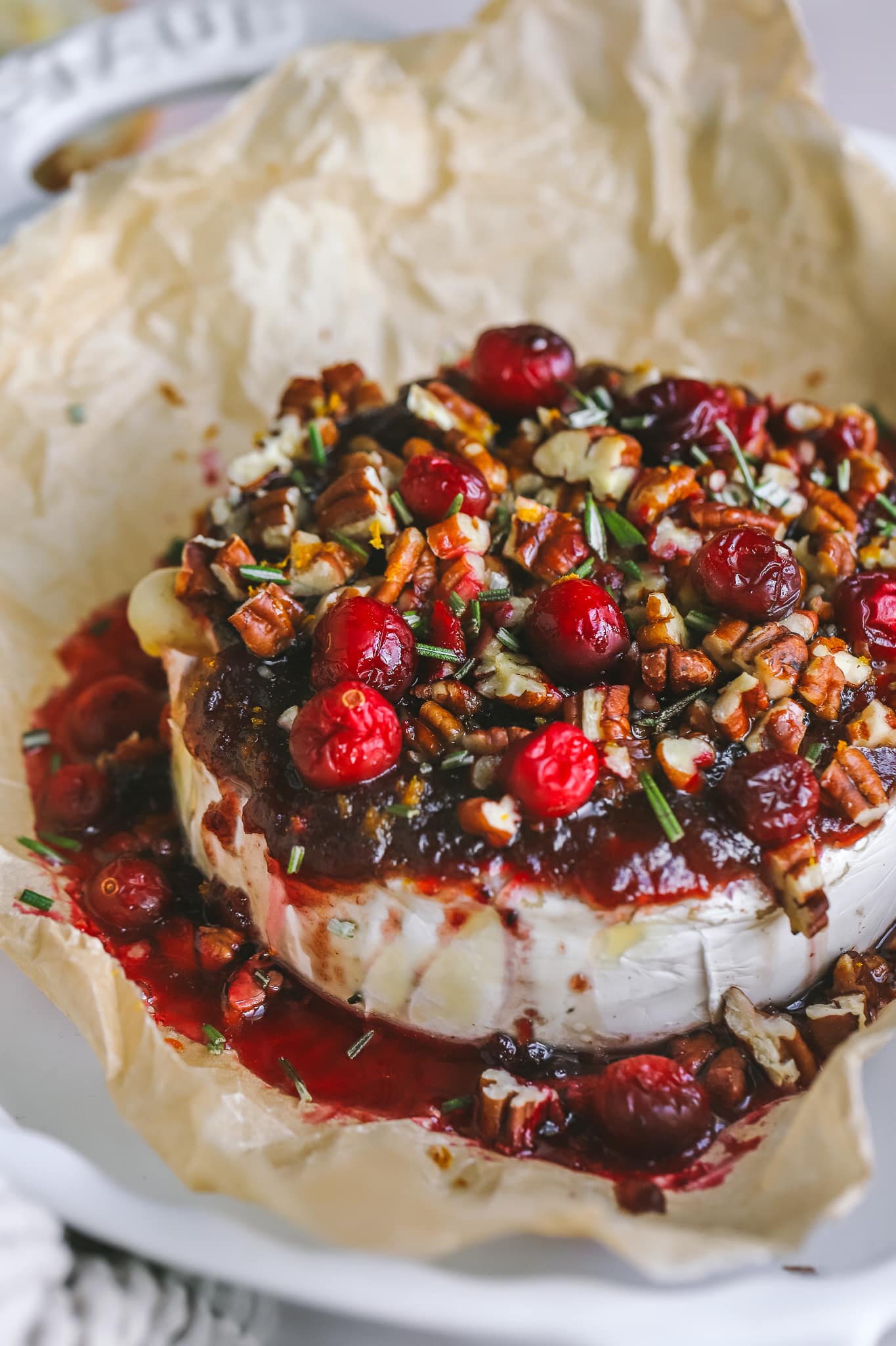 angled shot of cranberry baked brie in a serving dish