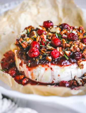 angled shot of cranberry baked brie in a serving dish