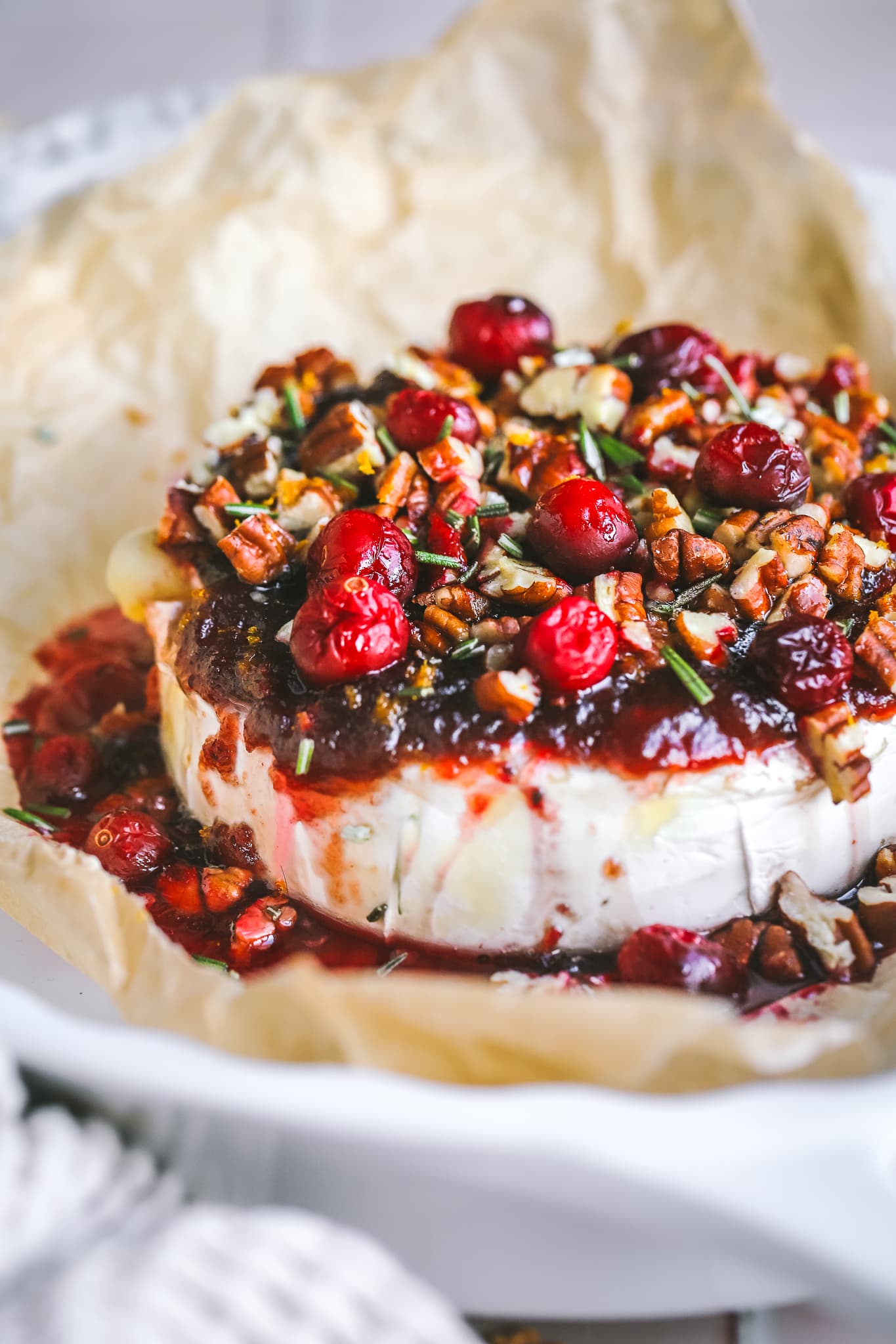 angled shot of cranberry baked brie in a serving dish