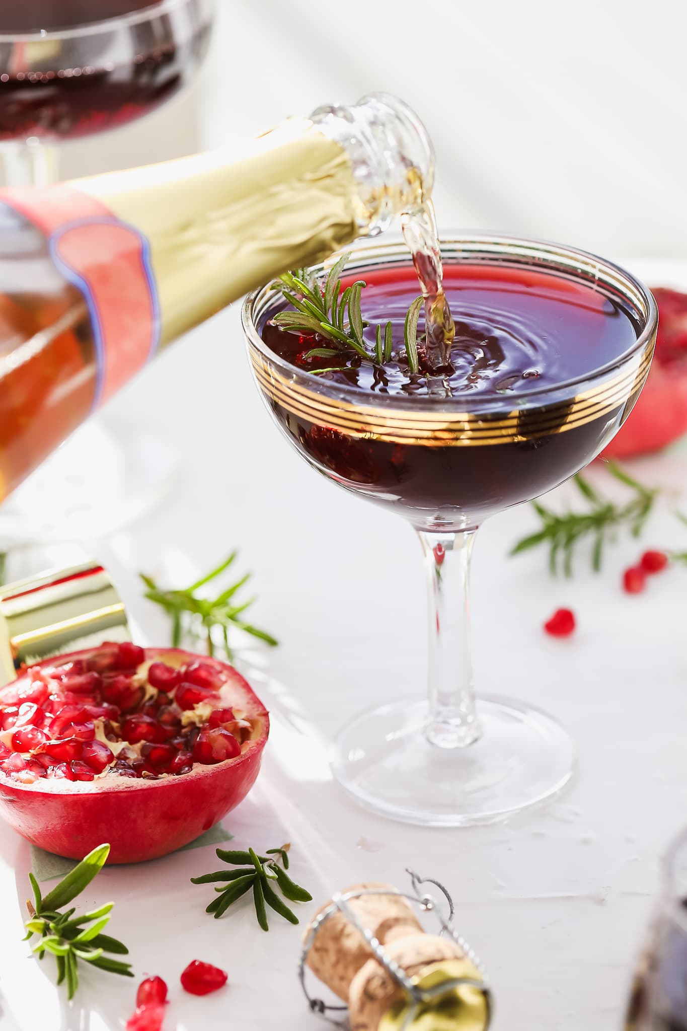 prosecco being poured into glasses with pomegranate vodka cocktails