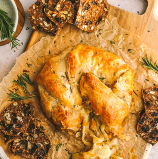 baked gruyere on a serving tray with crackers