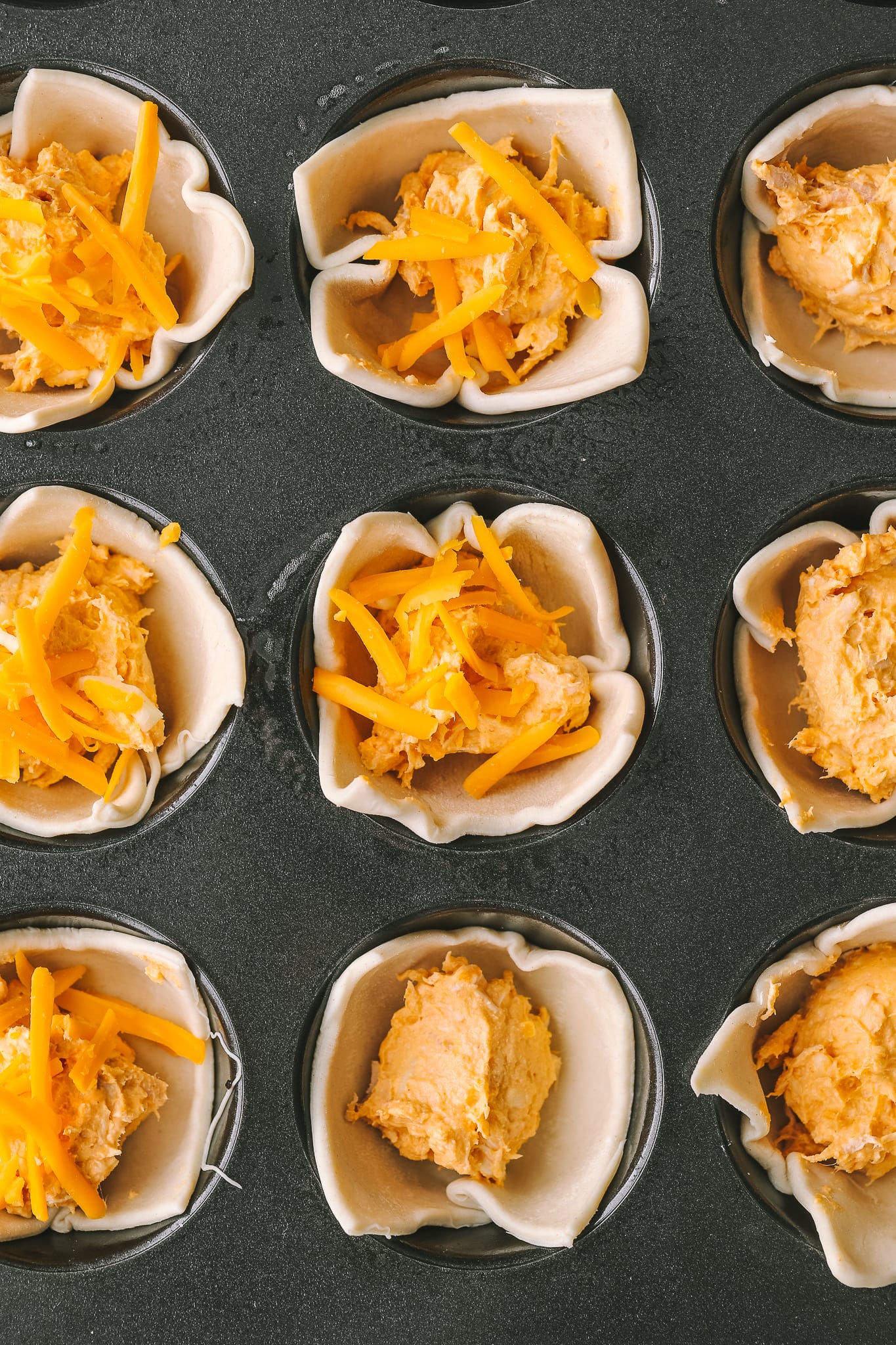 muffin tin with puff pastry, cheese and buffalo chicken filling