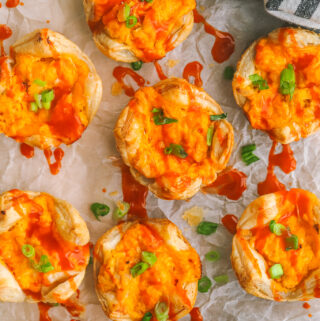 buffalo chicken bites on a serving tray drizzled with buffalo sauce