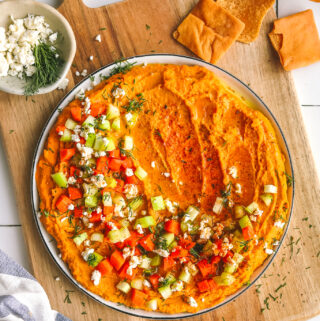 spicy buffalo hummus on a plate with garnishes