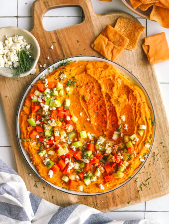 spicy buffalo hummus on a plate with garnishes