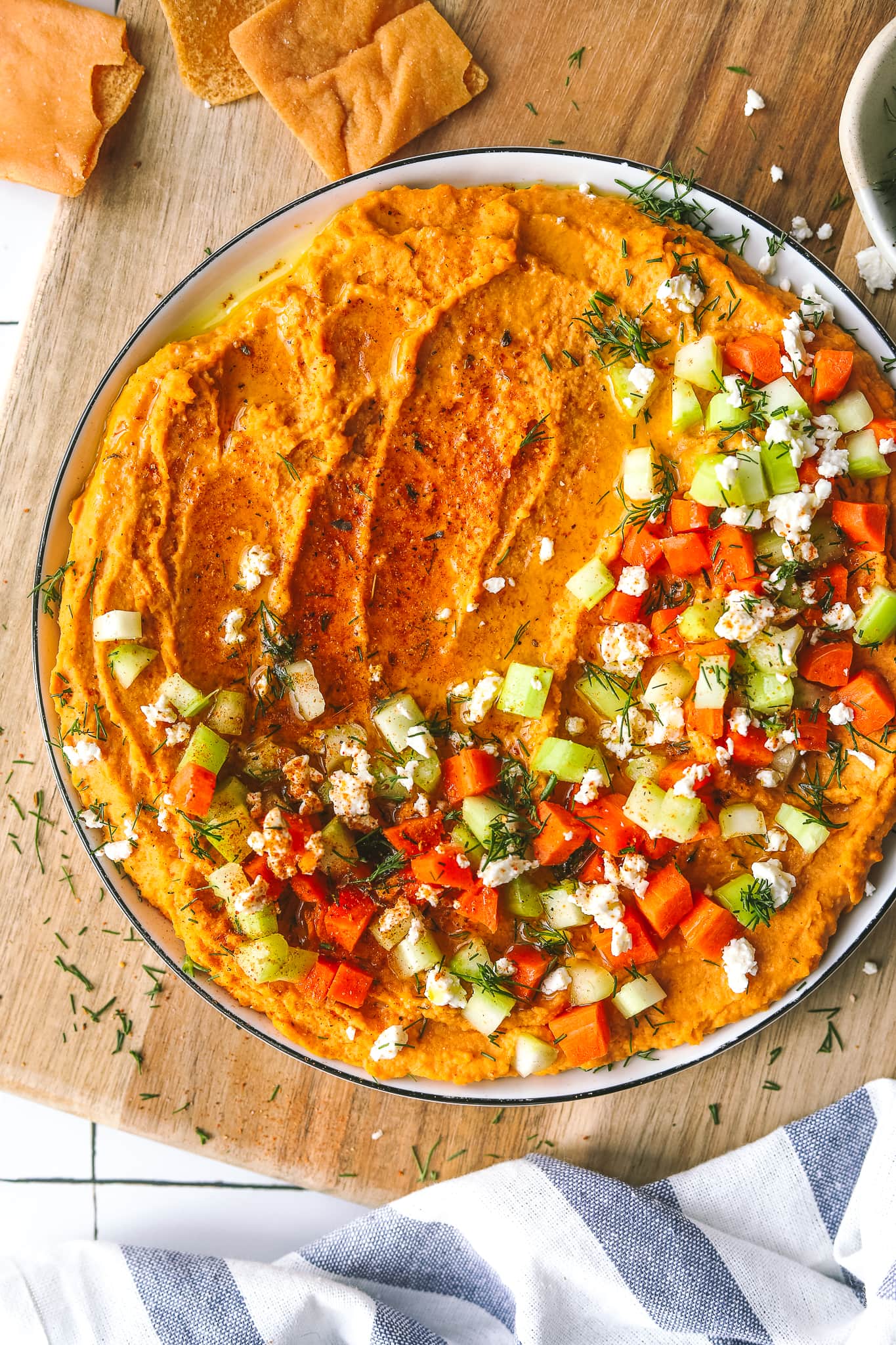 close up of spicy buffalo hummus on a plate with garnishes