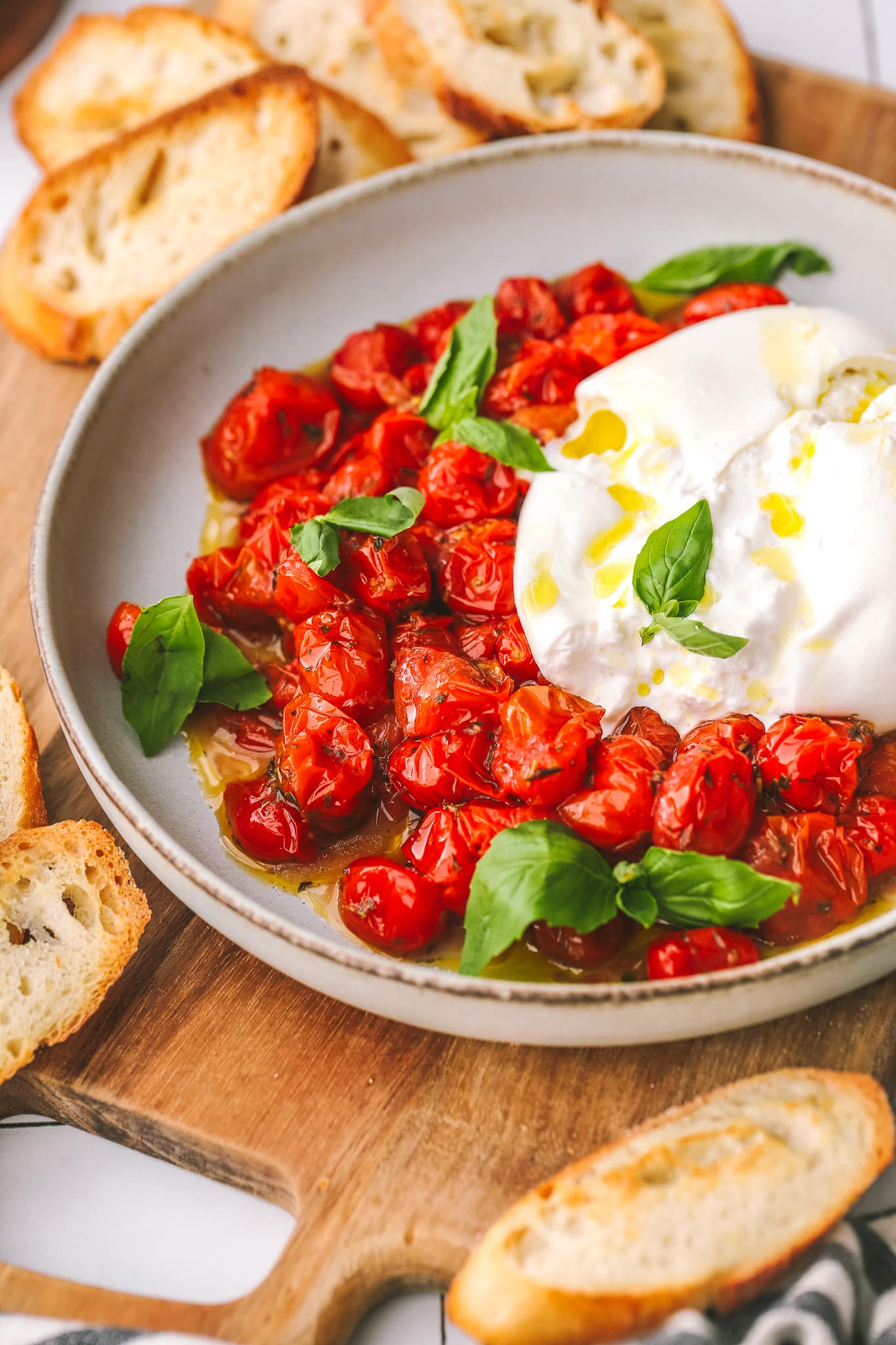 side angle of tomatoes in a bowl with burrata cheese