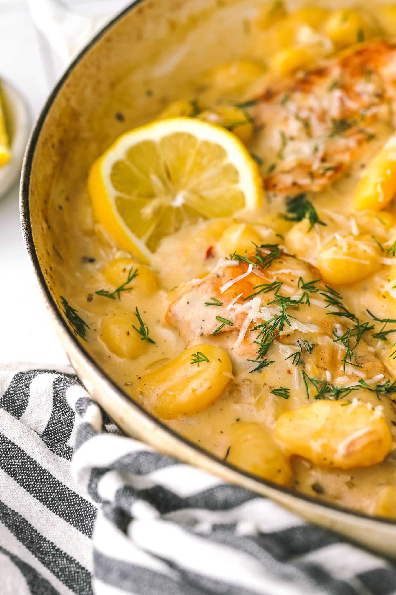 closeup of chicken, gnocchi and lemon in a large pan