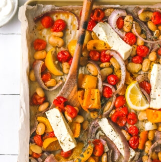 overhead photo of sheet pan dinner with feta with a serving spoon