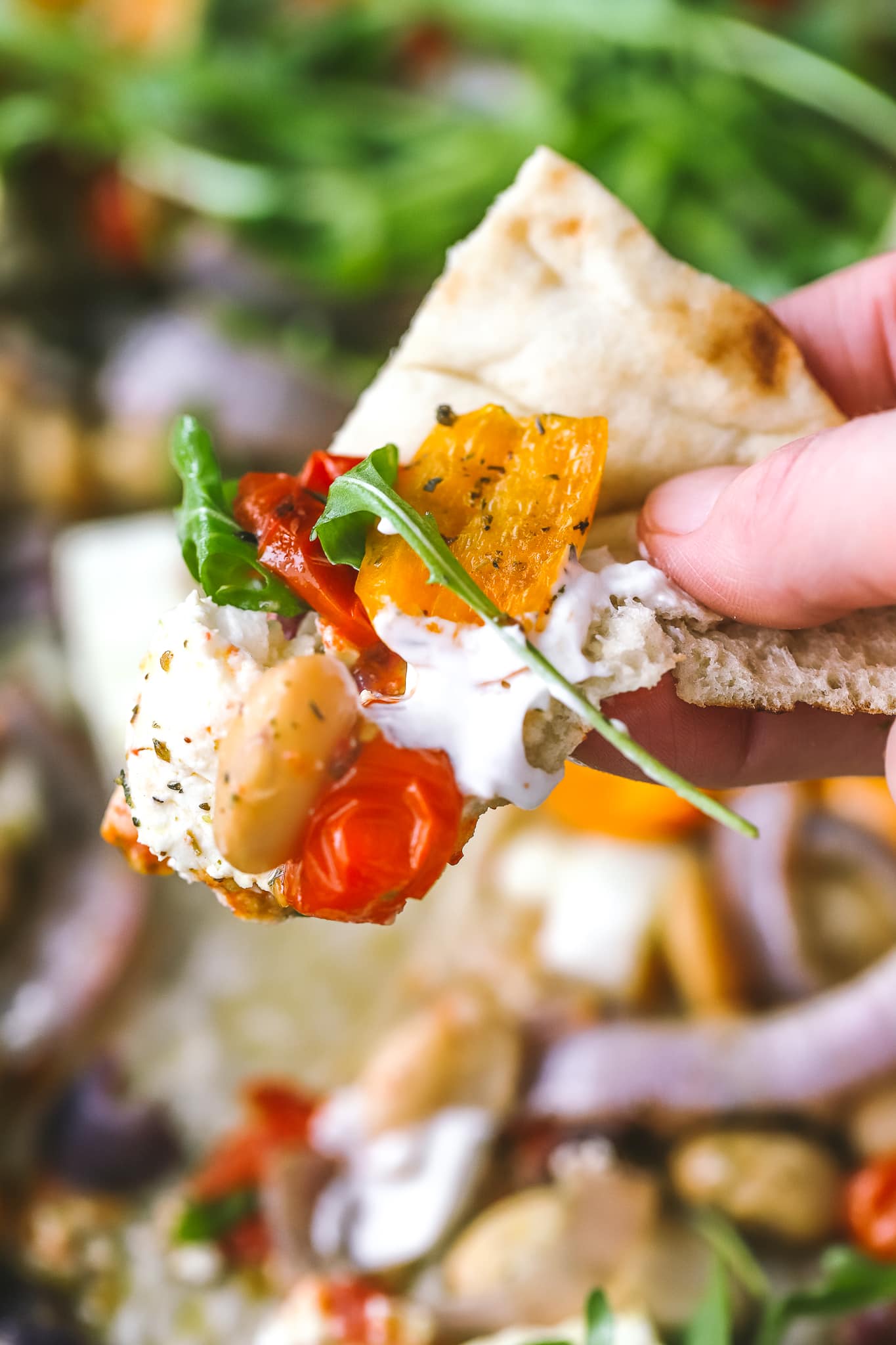 closeup of a pita with yogurt, vegetables and feat