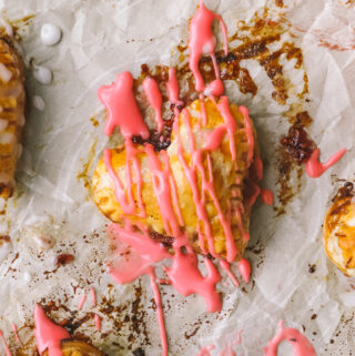 closeup of pink icing on a mini heart shaped pie