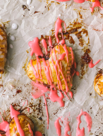 closeup of pink icing on a mini heart shaped pie