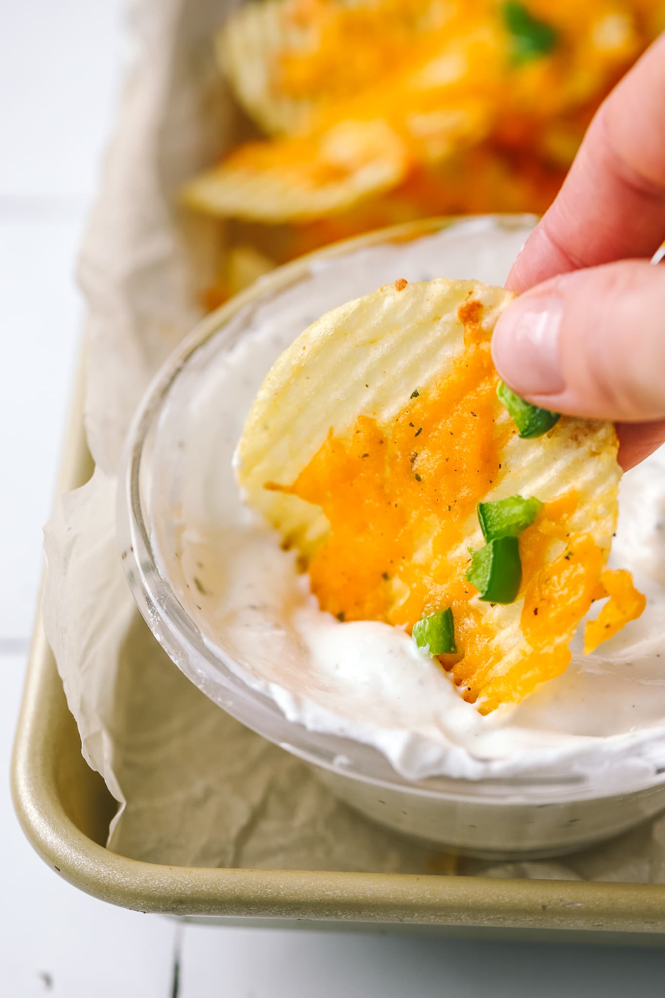 cheesy baked chip being dipped into ranch dip