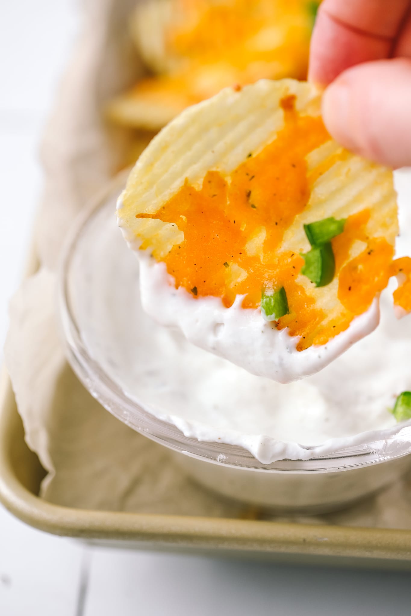 cheesy baked chip being dipped into ranch dip