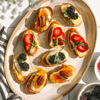 berries and brie on crostini on a platter