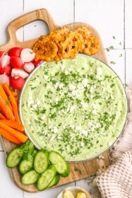 green goddess dip on a plate with vegetables and crackers