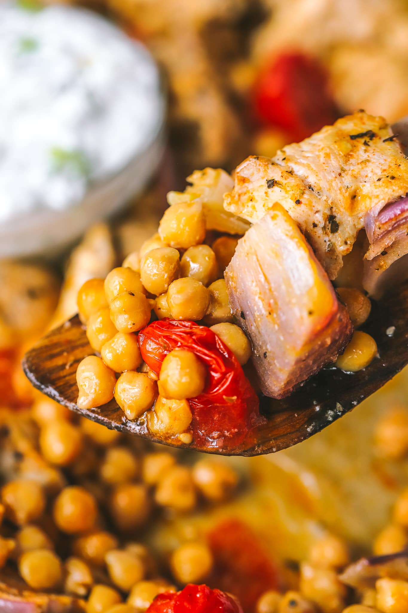 serving spoon with chickpeas, chicken and tomatoes 