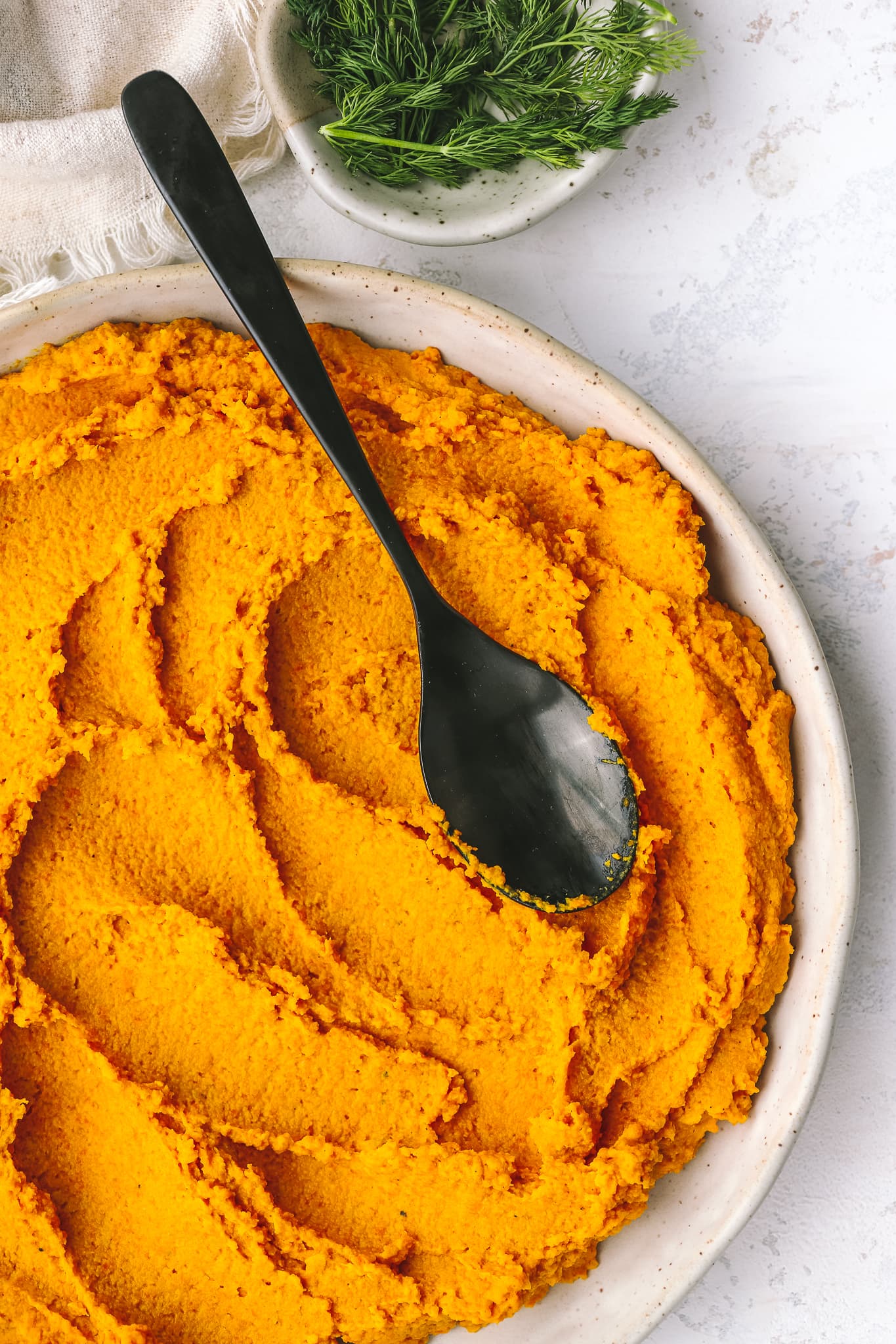 carrot hummus spread in a low bowl