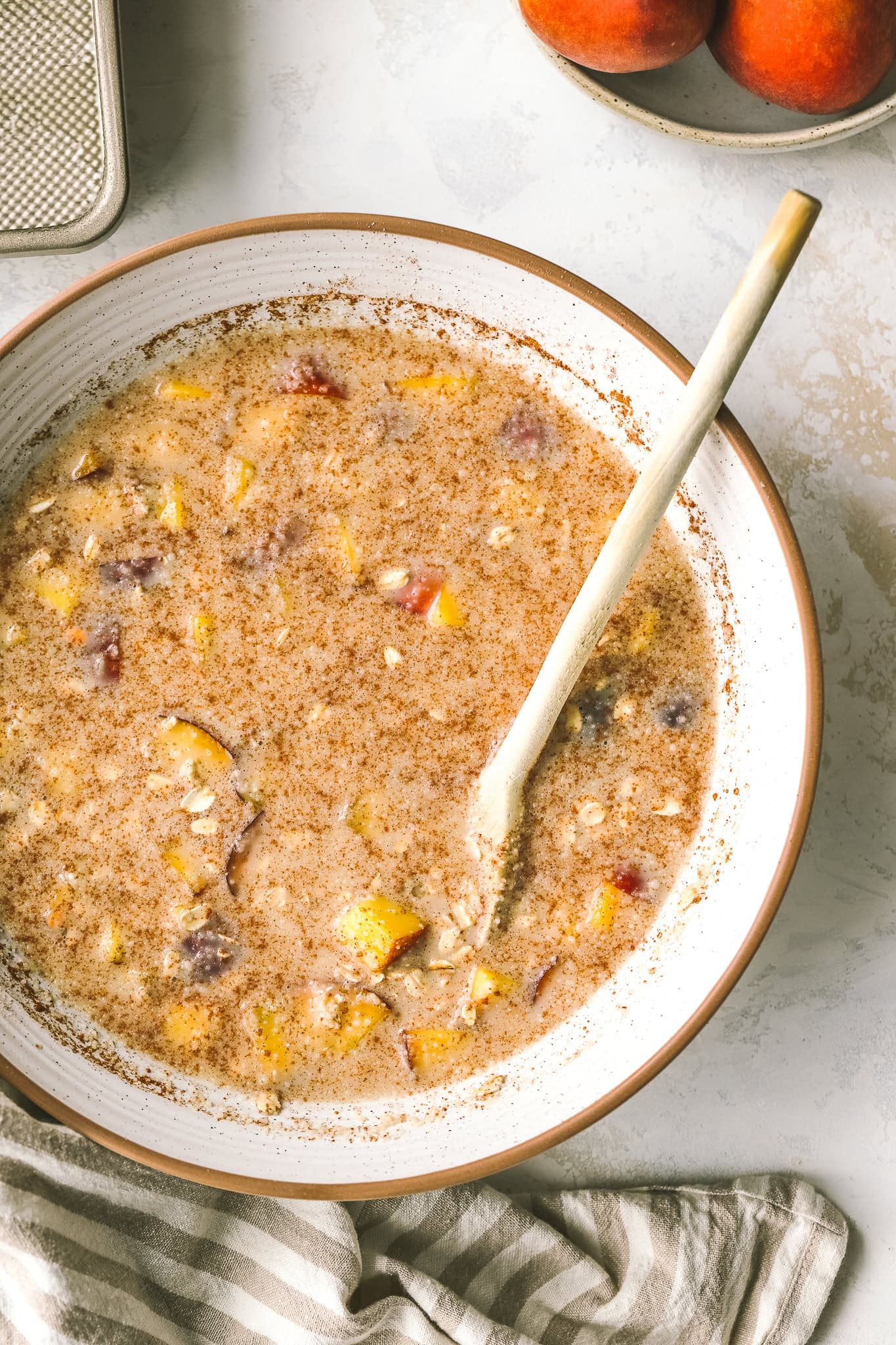 ingredients of peach oatmeal in a mixing bowl