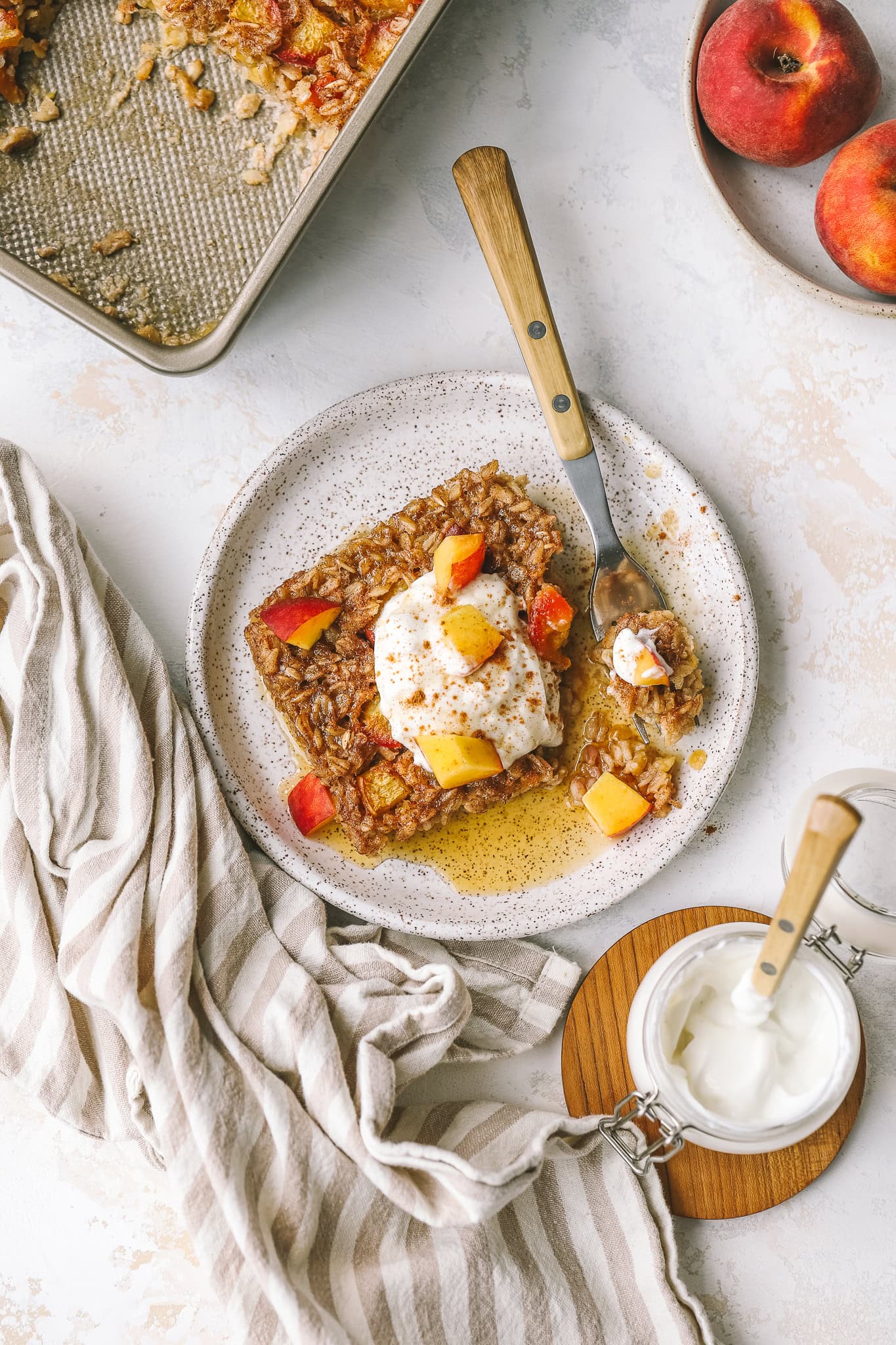 peach oatmeal on a plate with yogurt and peaches