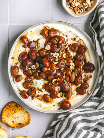overhead of whipped ricotta with roasted grapes and crostini