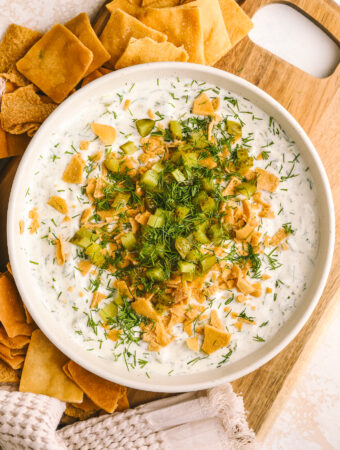 high protein dill pickle dip in a bowl served with pita chips