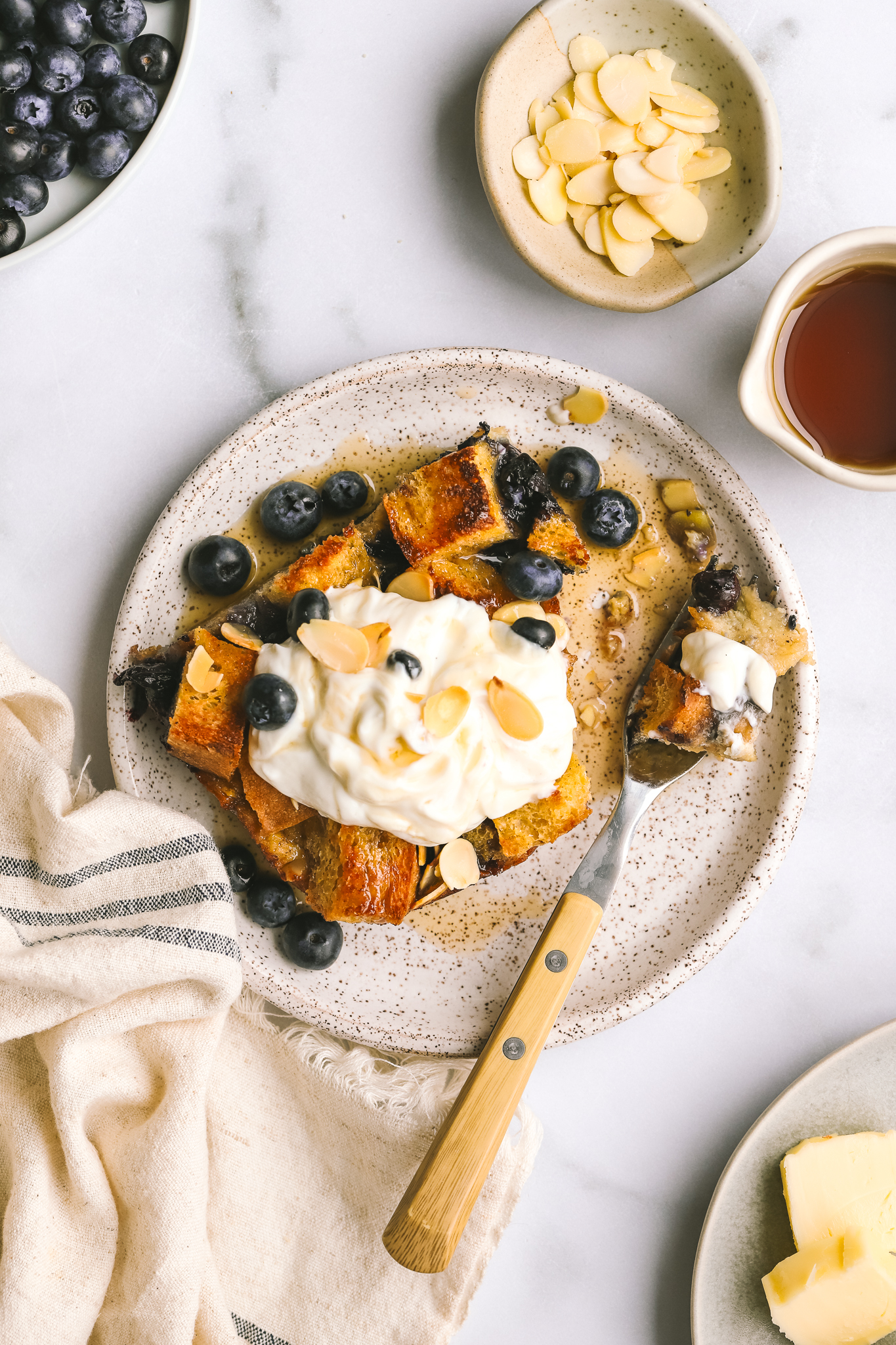a piece of blueberry baked french toast being eaten with a fork