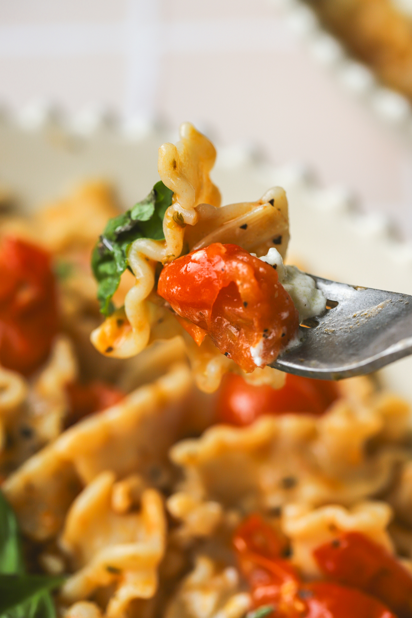fork with burst tomatoes and pasta