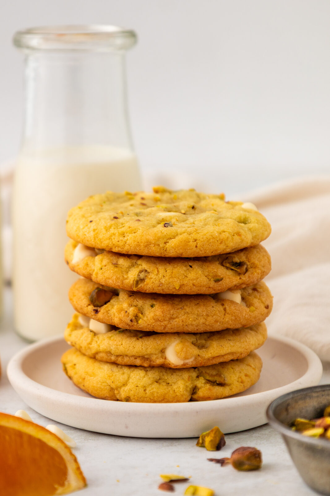 a stack of orange pistachio white chocolate cookies