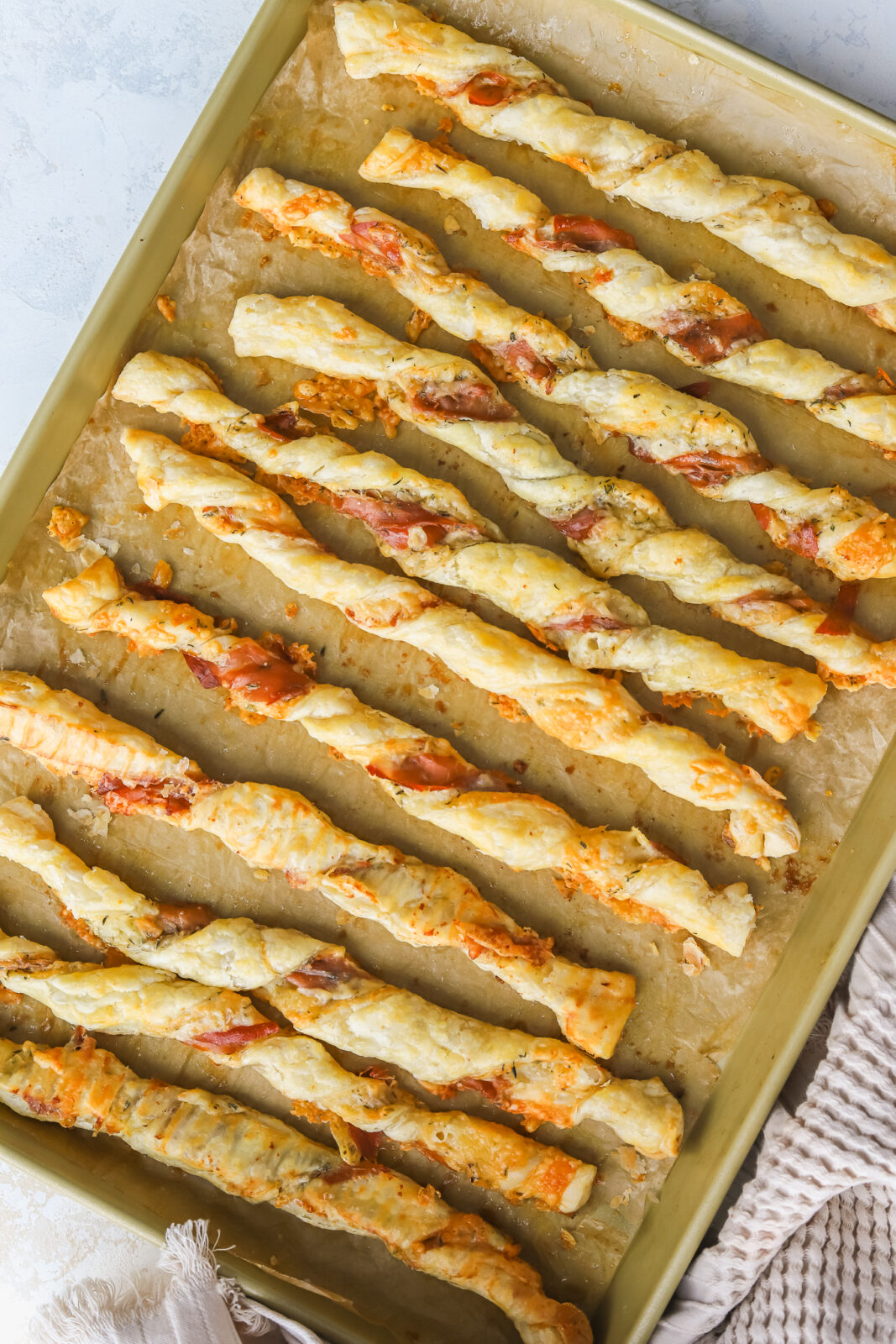baked puff pastry cheese twists on a baking sheet