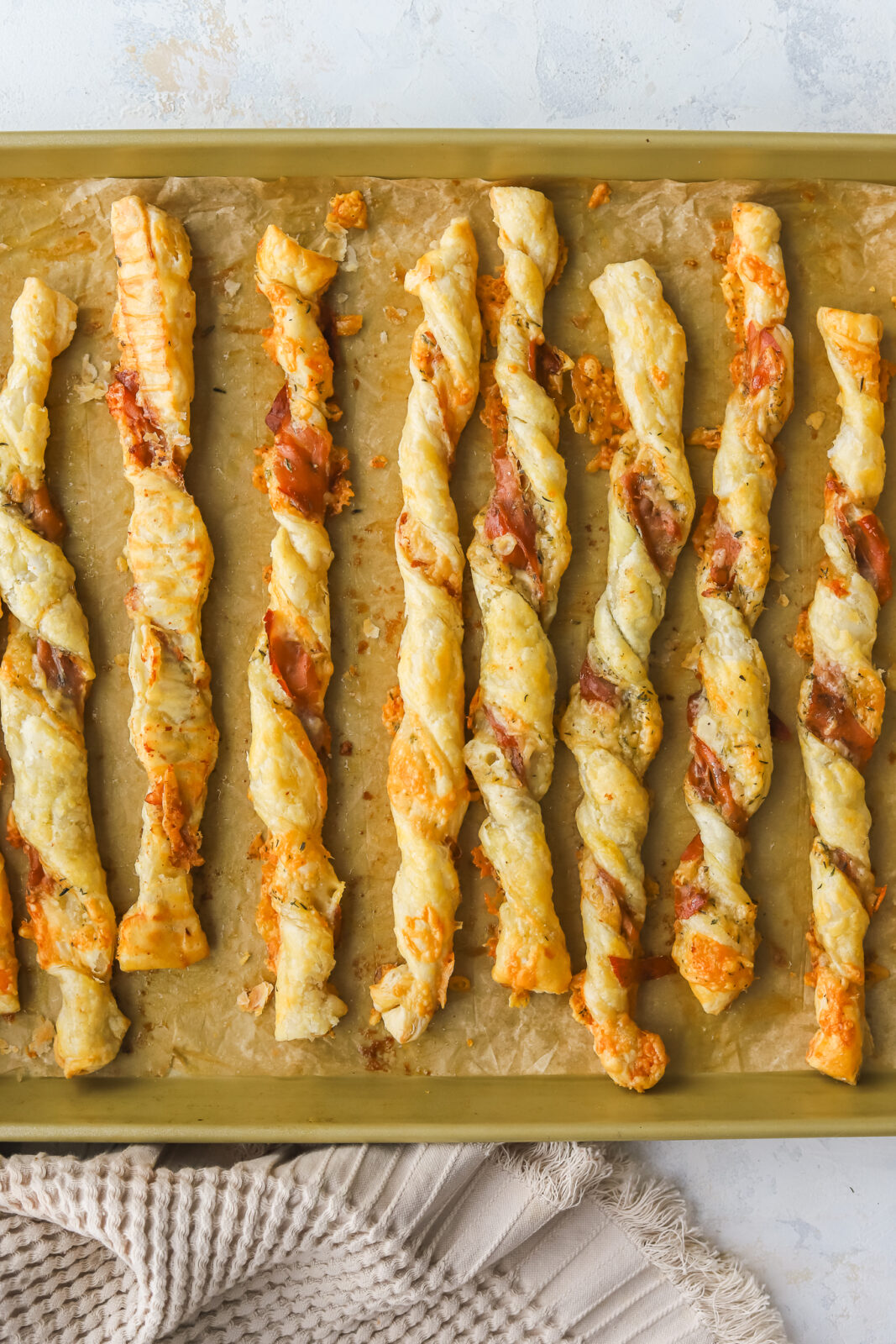baked puff pastry cheese twists on a baking sheet